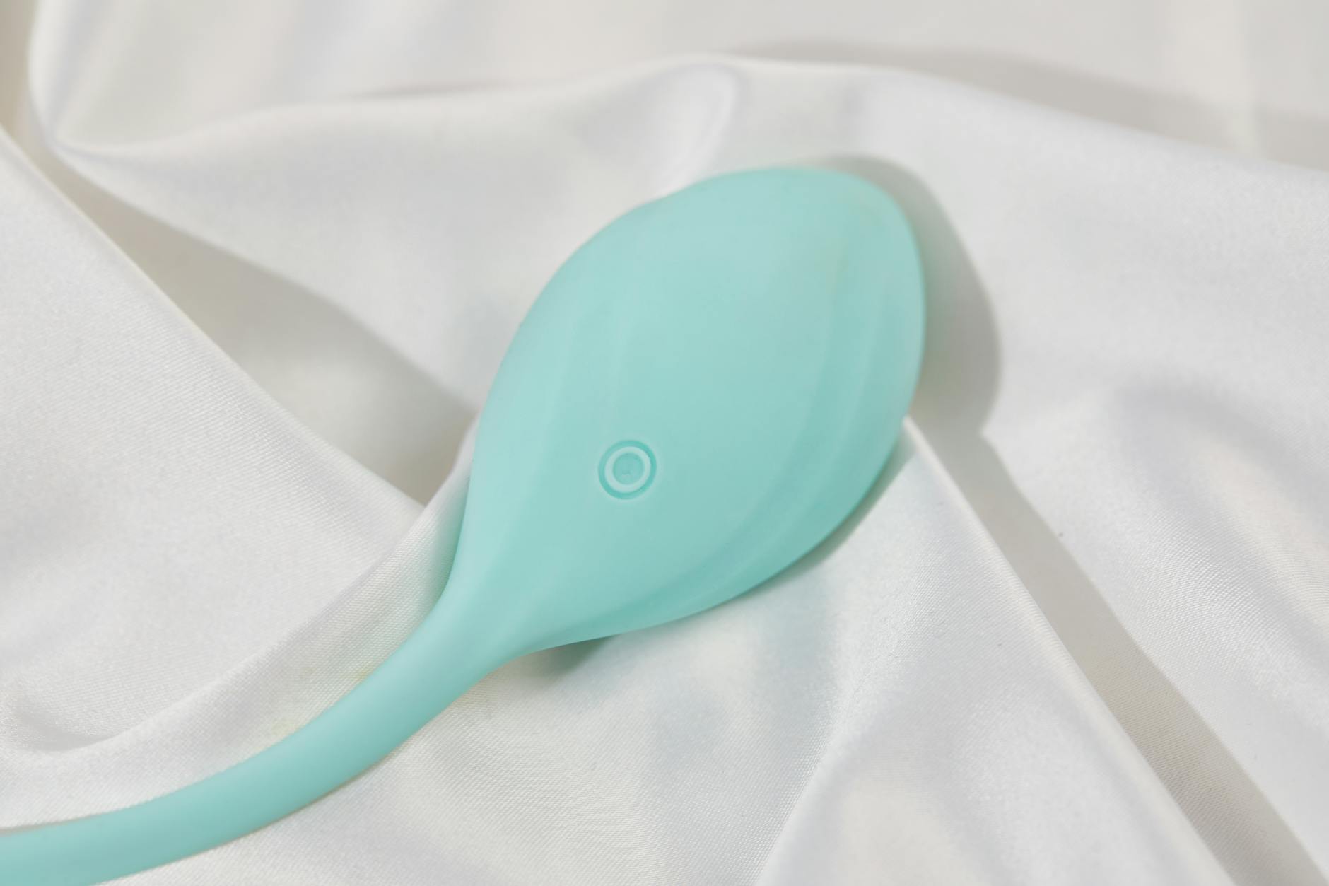 A hand holding fresh lemons on a pink background, representing the lemon vibrator design