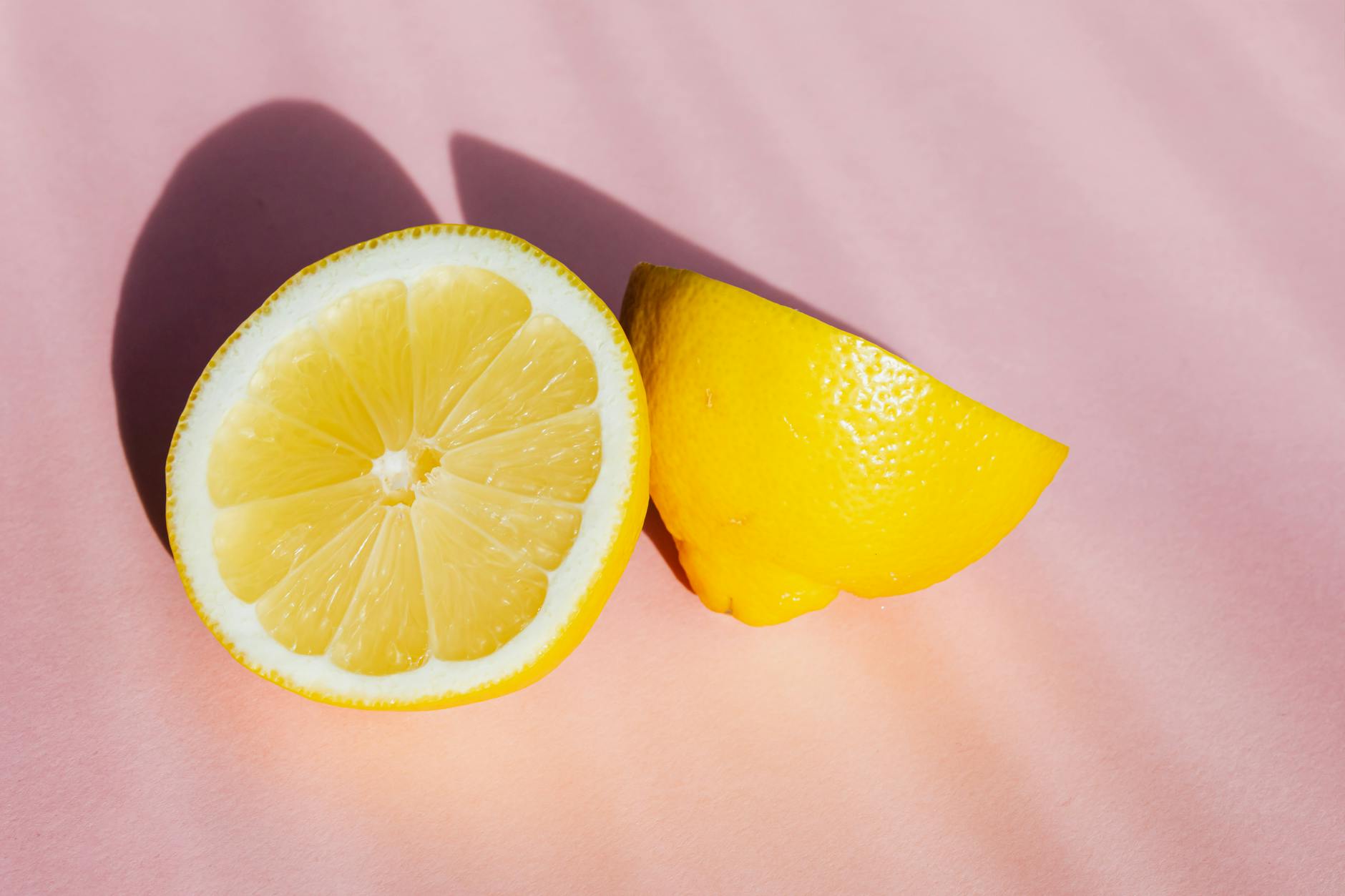Fresh lemon halves arranged on a pink background, suggesting freshness and new beginnings