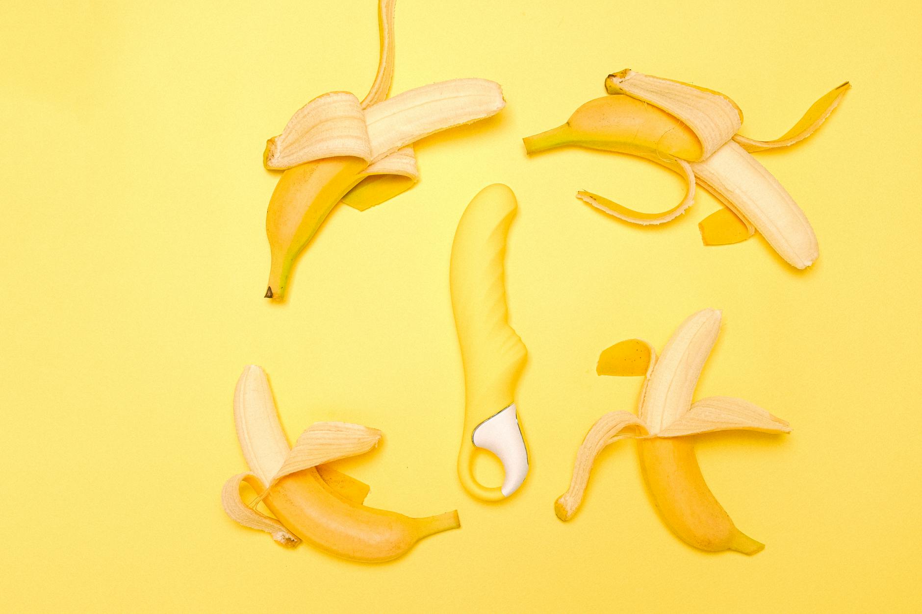 Yellow lemon vibrator surrounded by fresh lemons on bright background