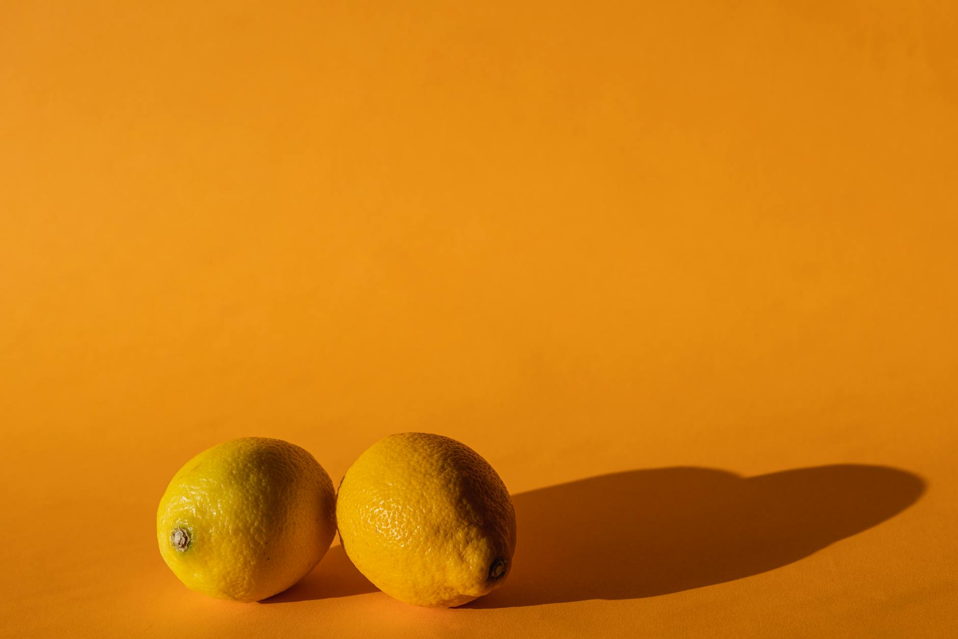 Ripe lemons on a bright yellow background representing refreshment and vitality